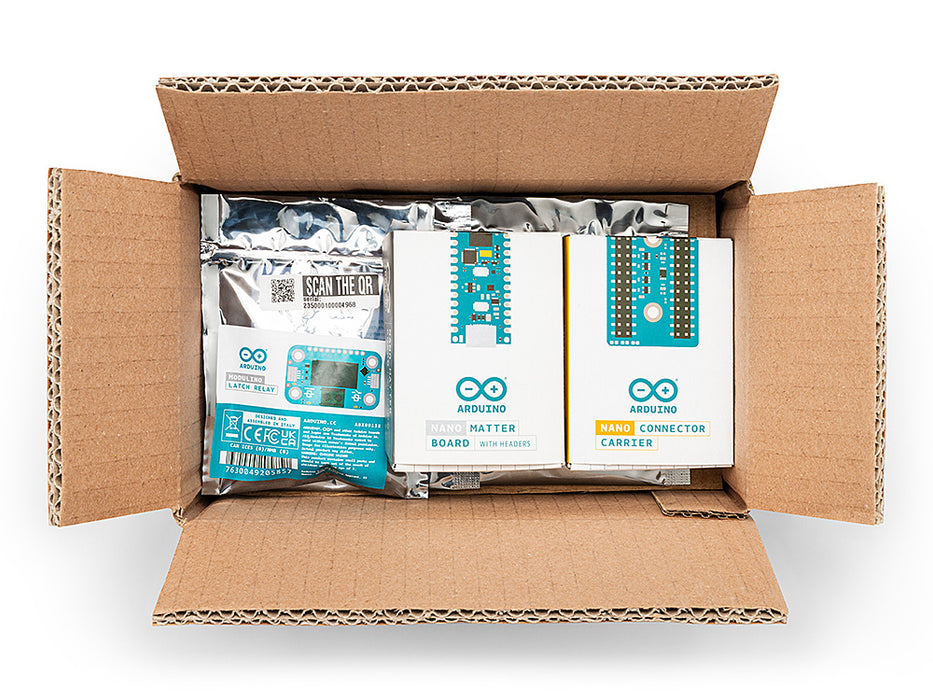 An open shipping box revealing the neatly packed Arduino Matter Discovery Bundle components in their official white and blue packaging.